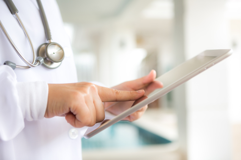 A clinician reviewing patient health records on a tablet